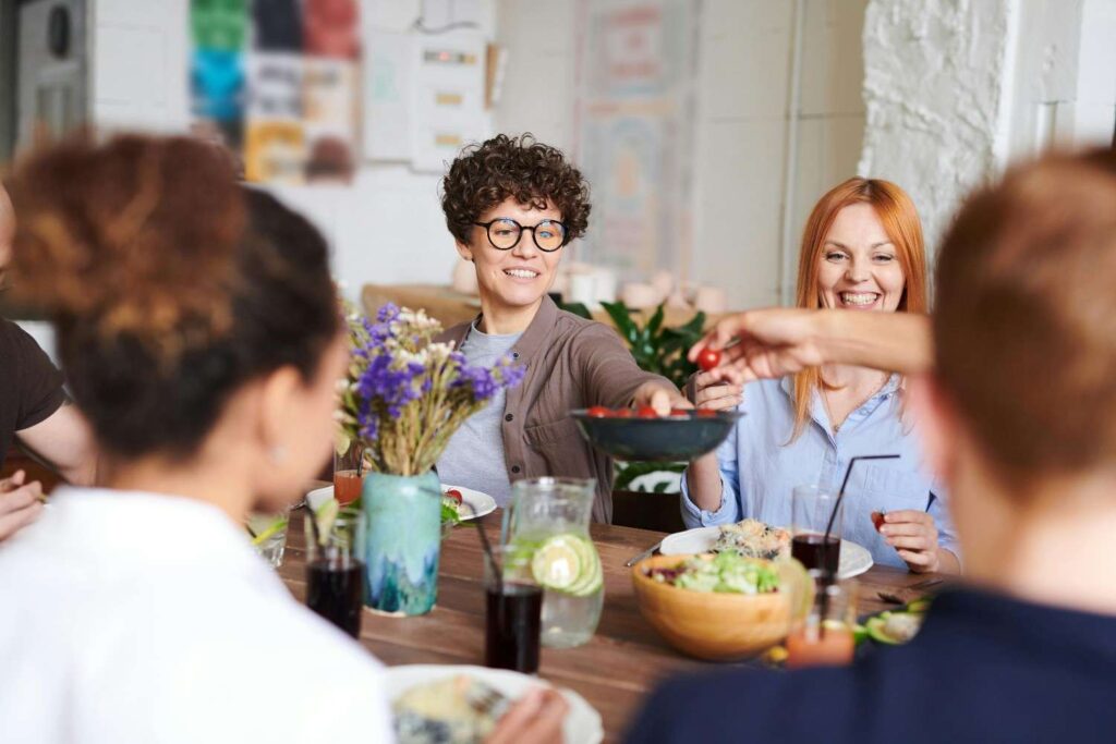  "People enjoying a meal together, representing the importance of social connection in the new wellness movement"