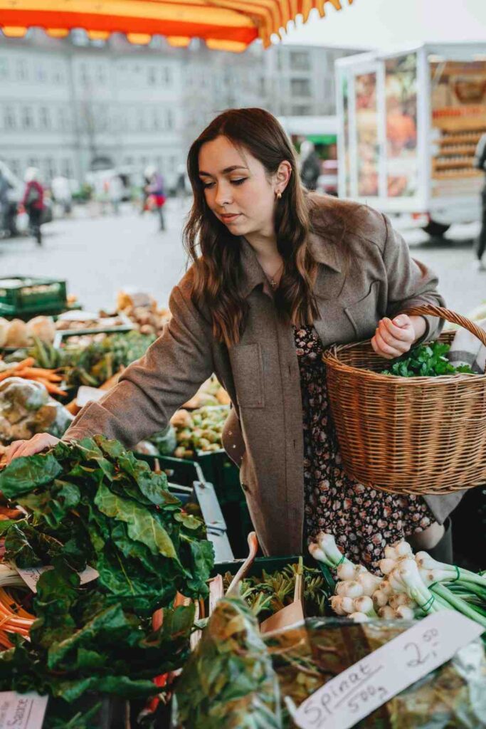 A person selecting fresh vegetables at a local market for healthy meal preparation