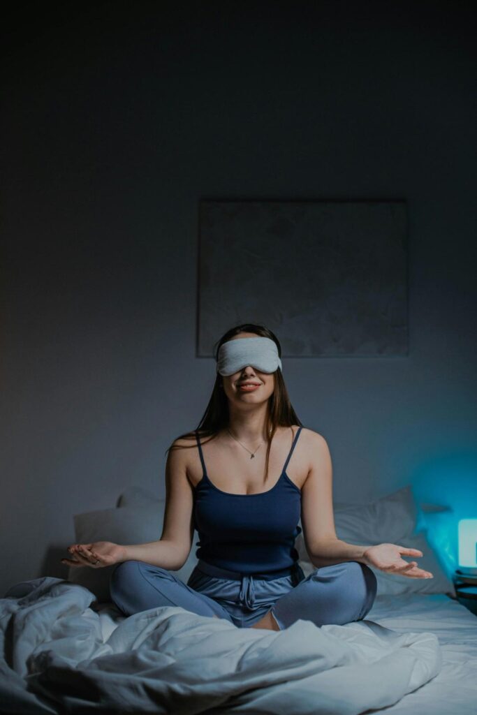 A person sitting in meditation pose inside a minimalist hotel room designed for silence and digital detox