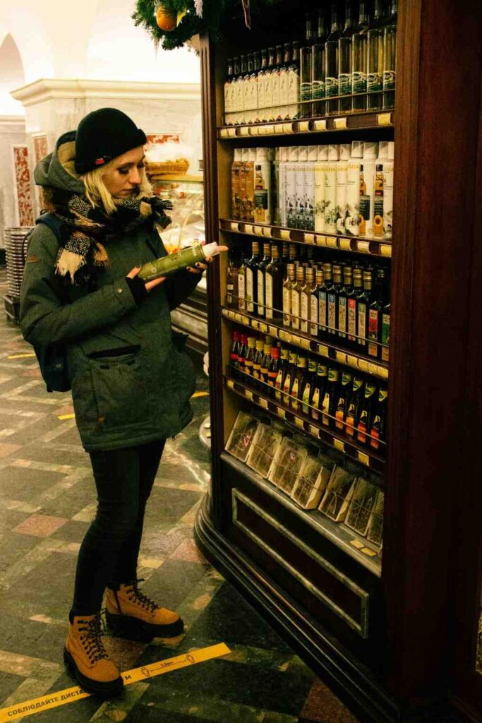 A shopper examining nutrition label on cooking oil bottle while shopping in grocery store aisle
