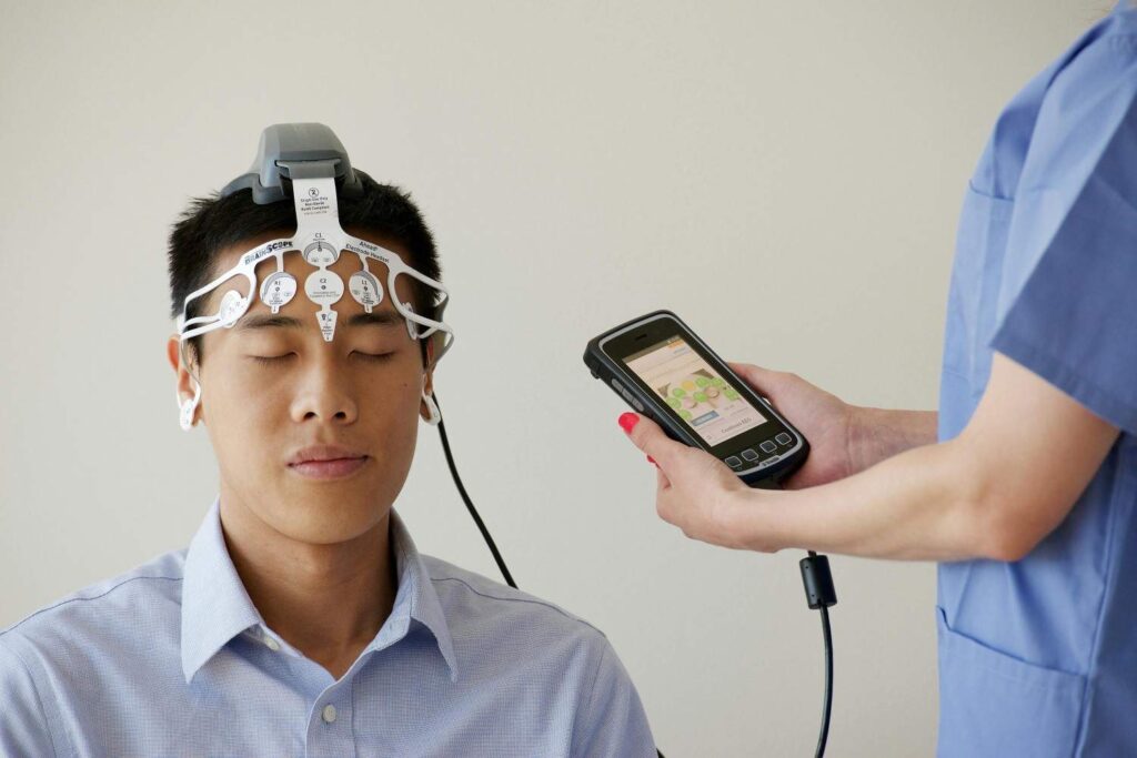Patient wearing wireless brain stimulation headset at home, using companion app for depression treatment