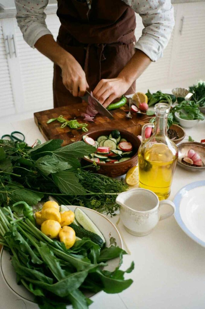A home cook preparing a balanced meal with spinach, avocado, salmon, and nuts, representing natural electrolyte sources. Electrolytes balance 2026
