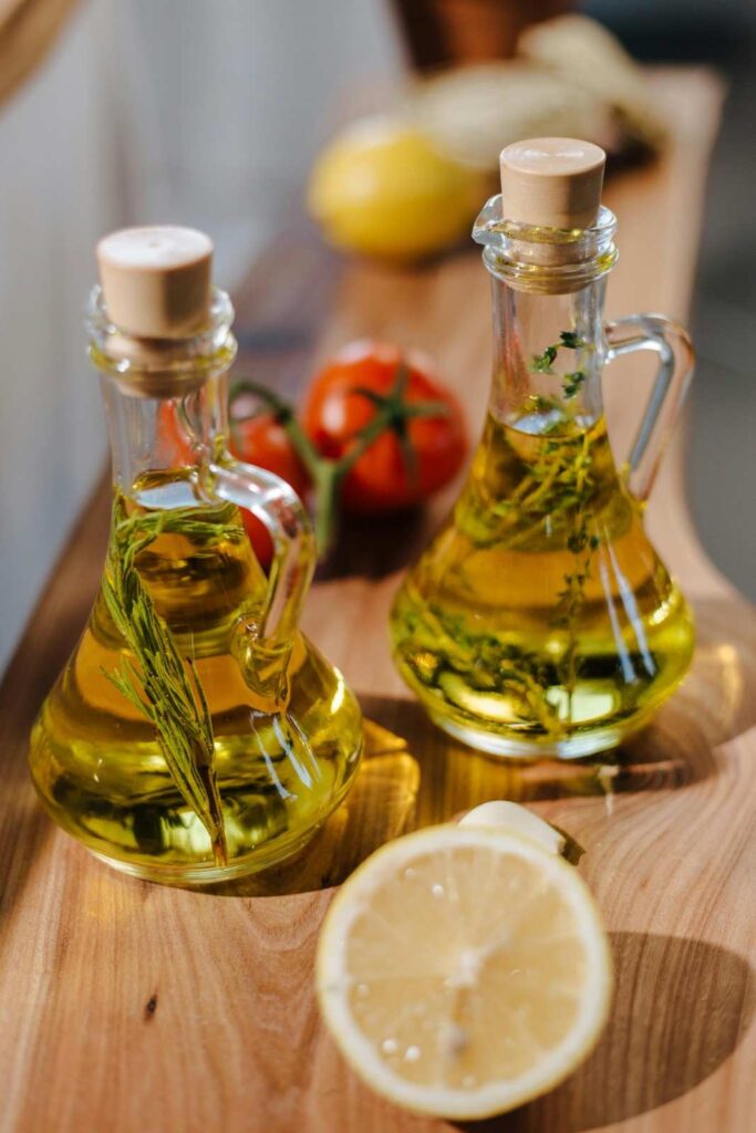Various cooking oil bottles, including olive oil, canola oil, sunflower oil, and coconut oil, arranged on a kitchen counter