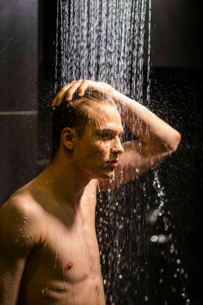 Person taking cold shower in morning to stimulate mitochondrial health