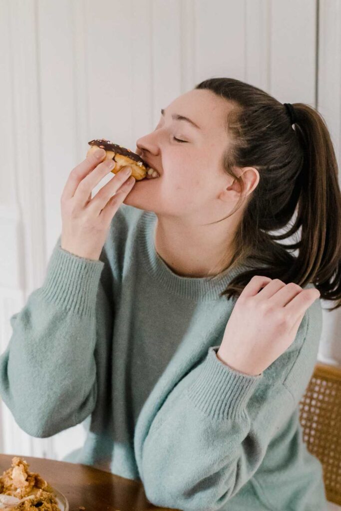 A person sitting at a table with a balanced meal, pausing to breathe before eating, representing mindful approach to cravings