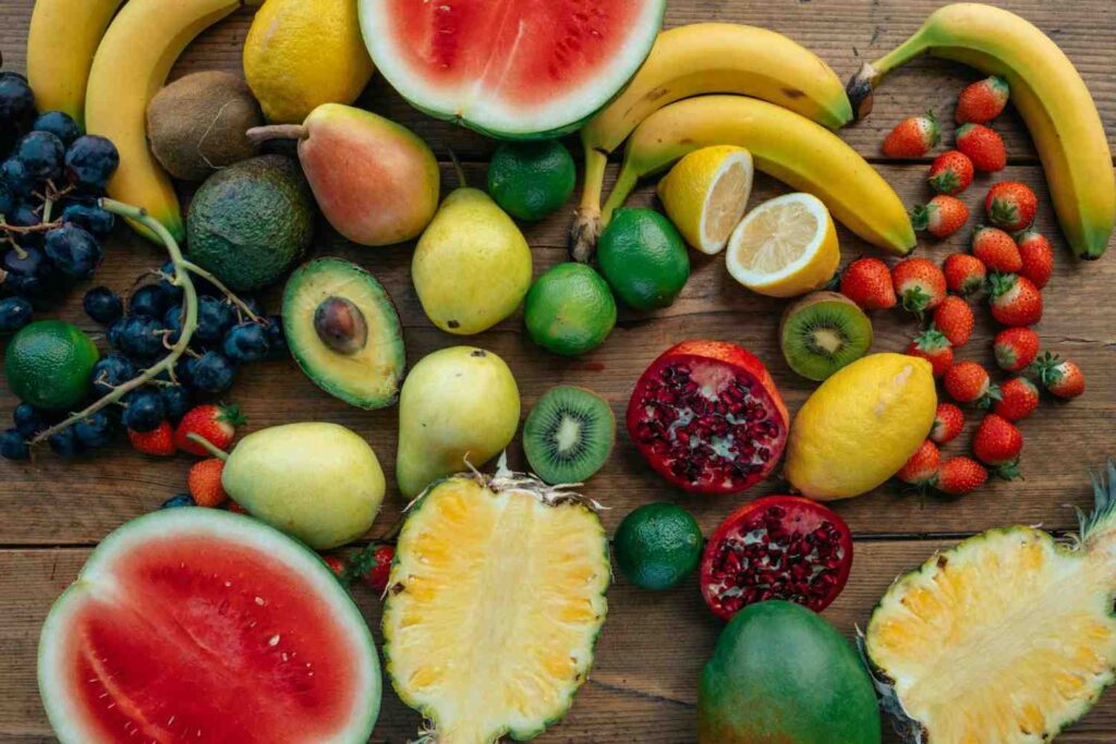 Colorful display of foods rich in electrolytes, including bananas, spinach, almonds, avocados, and sea salt on a wooden table.
