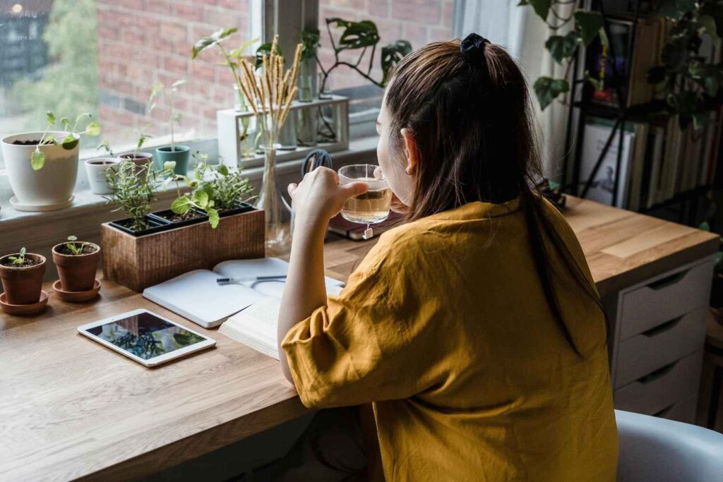 A person sitting peacefully with tea by a sunny window, representing calm and restored energy after setting boundaries: the power of saying no 2026
