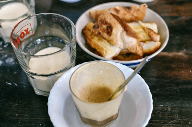  Bowl of red spicy curry with steam rising; glass of milk placed next to it, representing dairy as capsaicin neutralizer